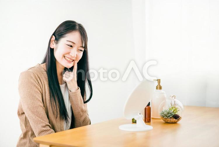 部屋で鏡を見る肌荒れが治った女性（笑顔） ニキビ,肌荒れ,鏡の写真素材