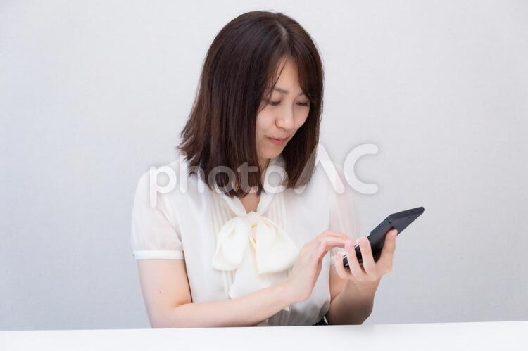 電卓を手に持って打っている女性 女性,ol,顔の写真素材