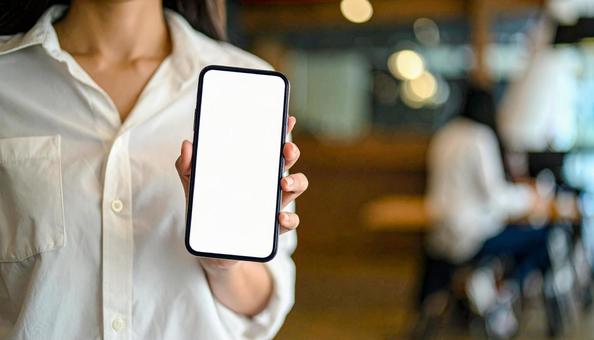 スマホを持つ日本人の若い女性の写真