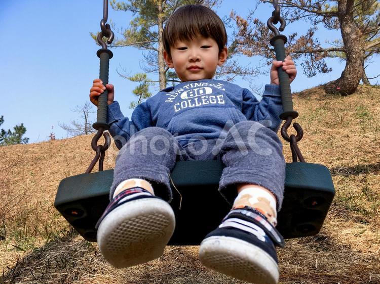 ＜素材＞秋の公園でブランコで遊ぶ男の子 子供,男性,人物の写真素材