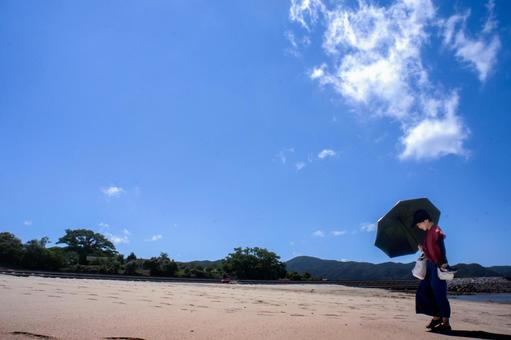 <素材>夏の海水浴場で遊ぶ日傘の女性 <素材>夏の海水浴場で遊ぶ日傘の女性 女性,人物,夏の写真素材