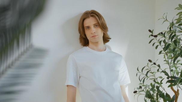 壁にもたれる白いTシャツを着た男性 男性,外国人,欧米人の写真素材