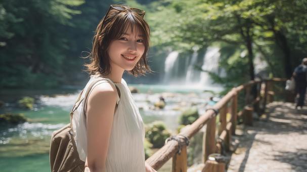 夏の深緑と渓流沿いの遊歩道と若い女性 夏の深緑と渓流沿いの遊歩道と若い女性の写真