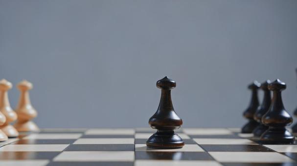 グレー背景のポーンが並んだチェスボード グレー背景のポーンが並んだチェスボードの写真