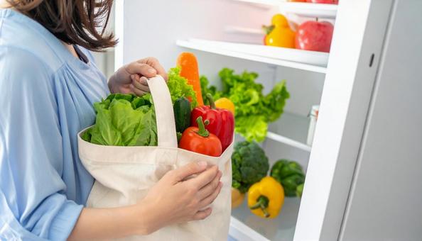 エコバッグから野菜を取り出し冷蔵庫へ エコバッグから野菜を取り出し冷蔵庫への写真