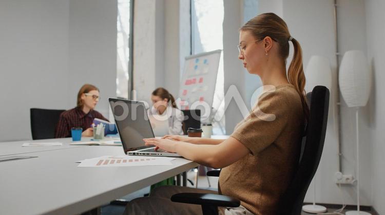 オフィスでノートパソコンを使っている妊娠中の女性 ビジネス,ビジネスマン,ビジネスウーマンの写真素材