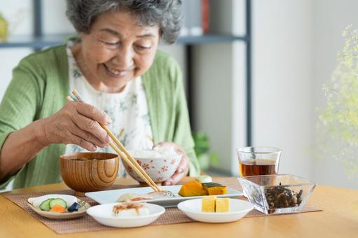 朝食を食べるシニアの女性 朝食を食べるシニアの女性 食事,焼き魚,シニアの写真素材