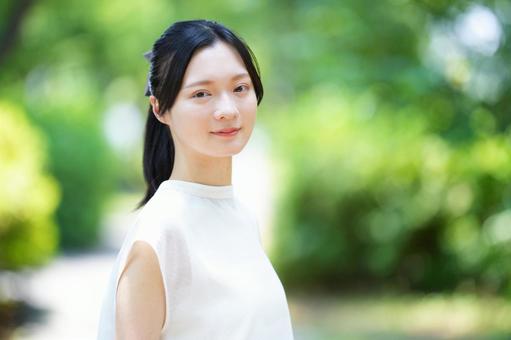 白いノースリーブワンピースの女性が横を向いて微笑む 女性,微笑む,振り向くの写真素材