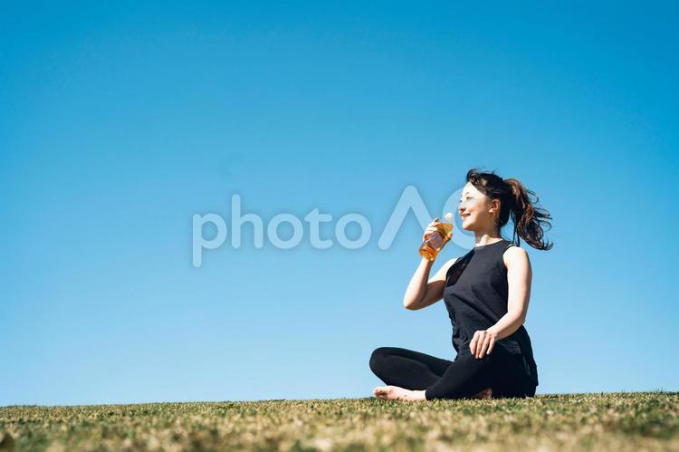 お茶を飲むスポーツウェアの女性 お茶,ドリンク,空の写真素材