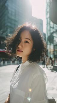 都会の光を浴びるショートヘアの女性の写真