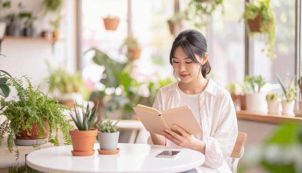 カフェで読書する女性 カフェで読書する女性の写真
