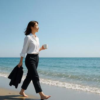 海辺で靴を脱ぎ波打ち際を歩く女性の写真