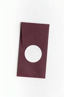 白いシールで封をした縦長の茶色い洋形封筒 白いシールで封をした縦長の茶色い洋形封筒の写真