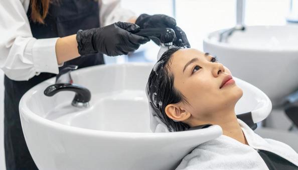 美容院でシャンプーされる女性の写真