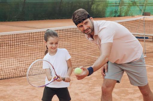 ネット前でテニスを学ぶ子供と男性 親子,女の子,男性の写真素材