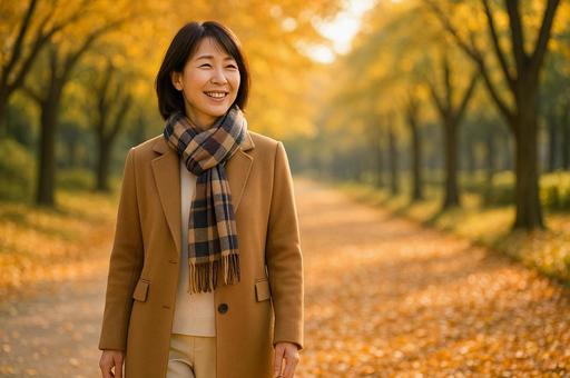 紅葉した公園を歩く女性 紅葉した公園を歩く女性の写真
