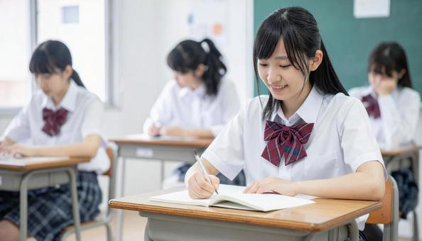 教室で勉強する女子学生・夏期講習・夏服 教室で勉強する女子学生・夏期講習・夏服の写真