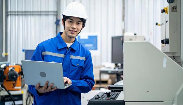 工場の三次元測定機を使う作業服の男性 工場の三次元測定機を使う作業服の男性の写真