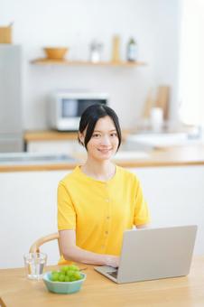 カメラ目線の黄色い服の女性の写真