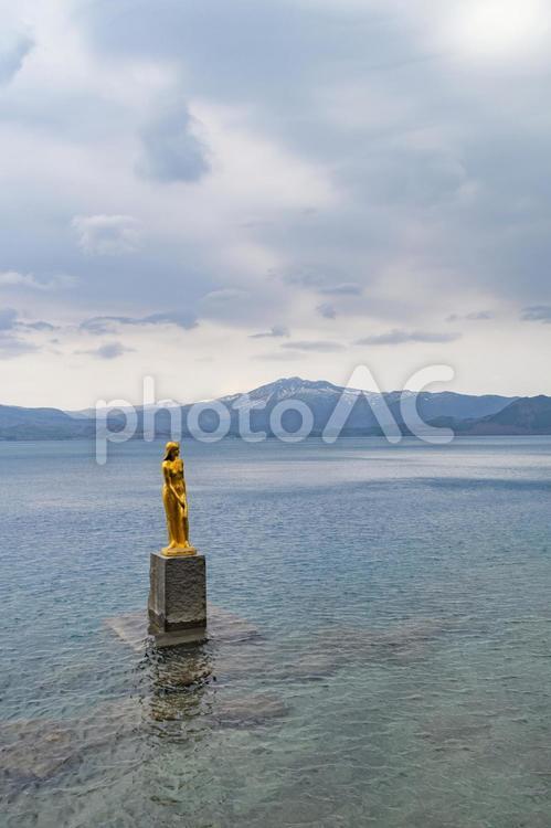 田沢湖のたつこ像と秋田駒ケ岳。日本、秋田 田沢湖,たざわこ,たつこ像の写真素材