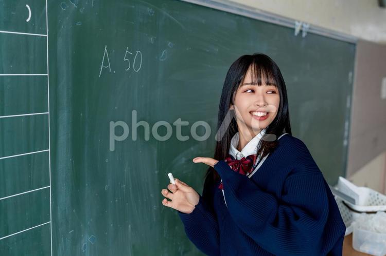 黒板にチョークで字を書く高校生 女性,女子高,高校生の写真素材