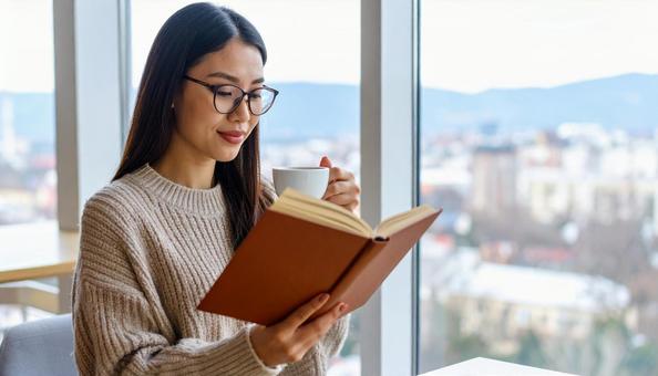 カフェで読書する若い日本人女性 カフェで読書する若い日本人女性の写真
