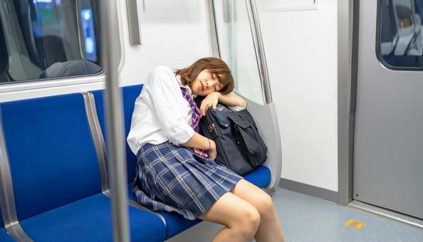 通学中に電車で爆睡する女子学生 通学中に電車で爆睡する女子学生の写真
