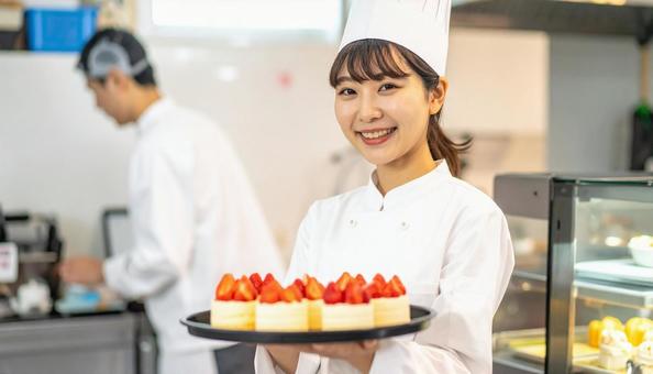 ケーキを陳列しているアルバイトをする女性 ケーキを陳列しているアルバイトをする女性の写真