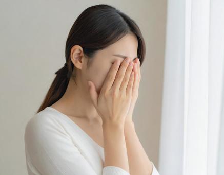 顔を隠す若い女性　1の写真