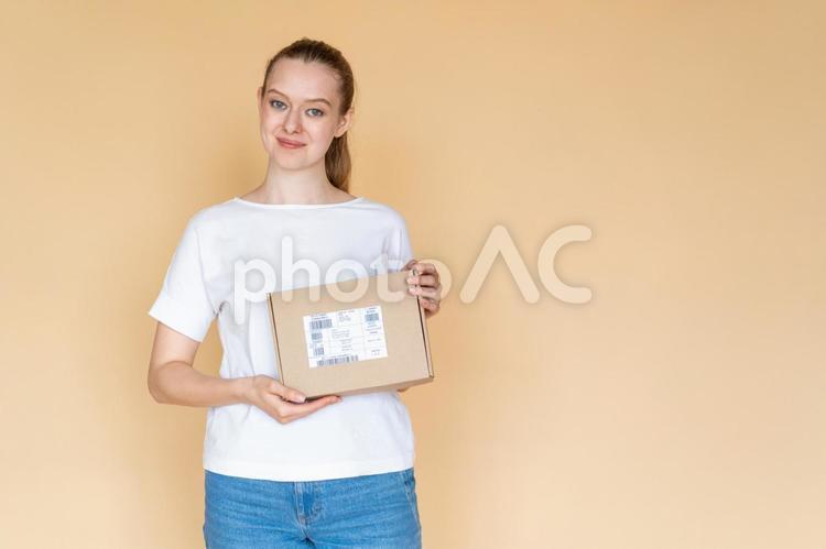 カメラ目線で箱を持つ女性 女性,荷物,持つの写真素材
