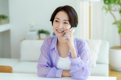 スマホで電話するミドル女性 スマホ,笑顔,女性の写真素材