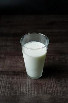 木製テーブルに置かれたミルクの写真