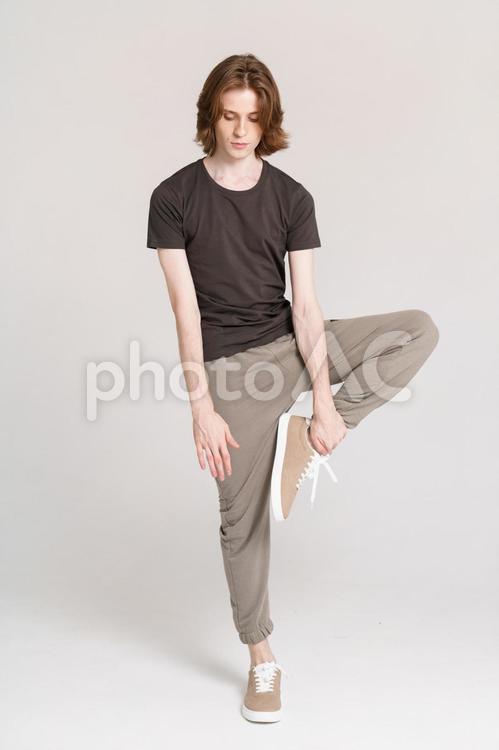 左足を持ち片足で立つ男性 男性,片足立ち,ポーズの写真素材