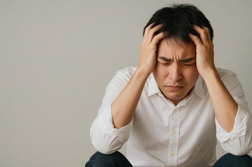 頭を抱えて考え込む、困った男性 頭を抱えて考え込む、困った男性の写真