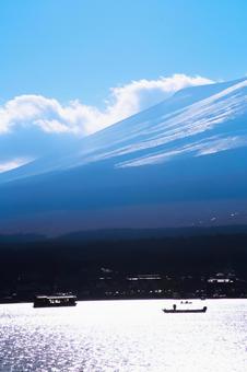 富士山とボートが浮かぶ静かな湖畔の風景の写真