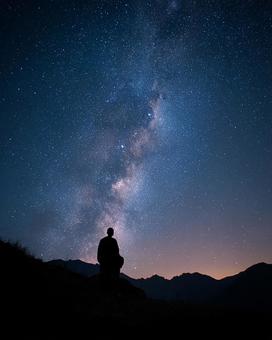 満天の星空の下、瞑想する僧侶 満天の星空の下、瞑想する僧侶の写真