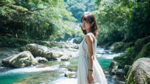 夏の渓流沿いの遊歩道に立つ若い日本人女性 夏の渓流沿いの遊歩道に立つ若い日本人女性の写真