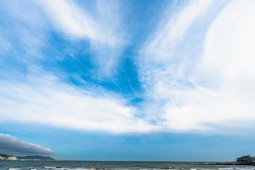 青い大空と海沿いの街並みの写真