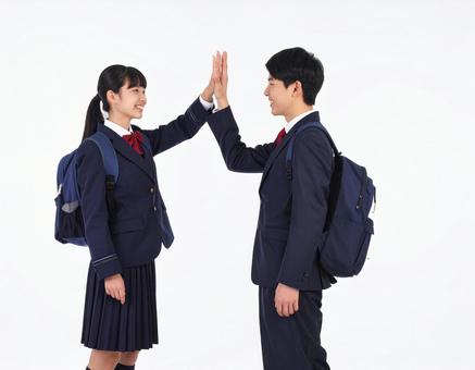 ハイタッチする高校生の男女生徒の写真