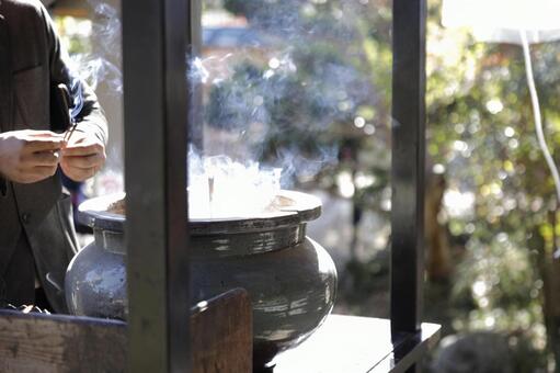 線香を香炉に入れる男性 神社,香炉,煙の写真素材