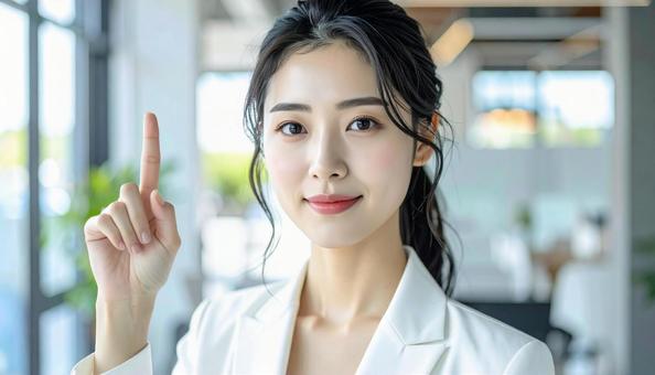 自信のある表情で指さすビジネス女性の写真
