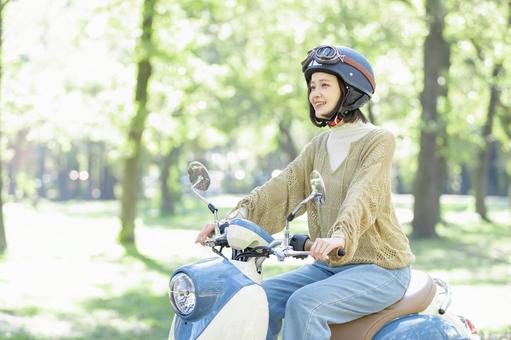 バイクに乗る若い女性 バイクに乗る若い女性の写真