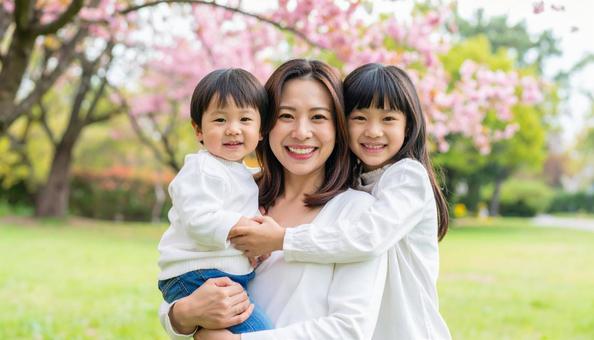 緑の中で遊ぶ3人の仲良し親子 緑の中で遊ぶ3人の仲良し親子の写真