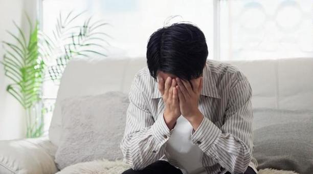 ソファで落ち込むアジア人男性 ソファで落ち込むアジア人男性 男性,落ち込む,ショックの写真素材