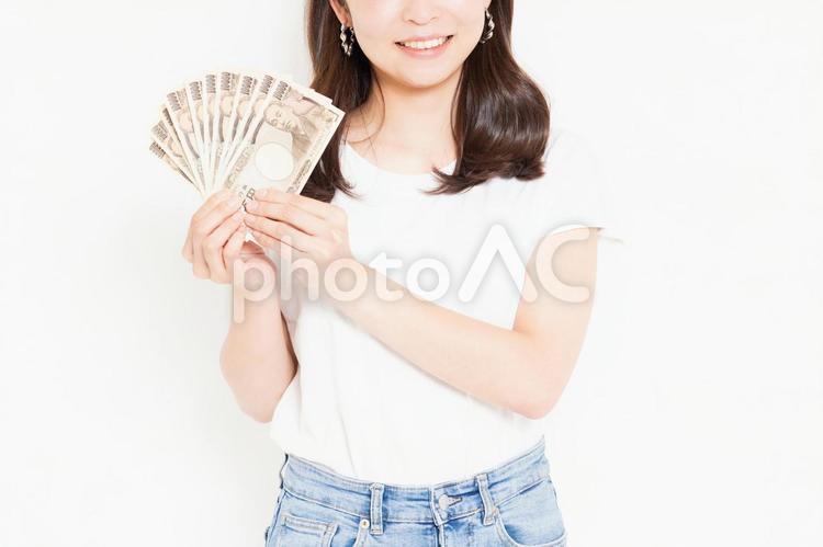 お金を持って喜んでいるTシャツを着た若い女性 お金,女性,金の写真素材