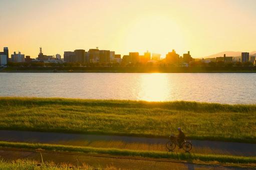 家へと続く河川敷 夕焼け,川,橋の写真素材