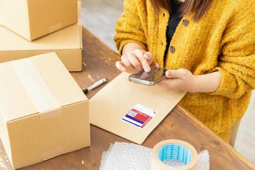 荷物の発送準備をする女性 配送,配達,段ボールの写真素材