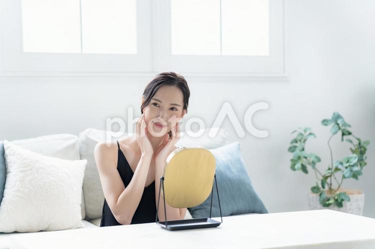 鏡を見るワンピースを着た女性 スキンケア,朝,ビューティーの写真素材