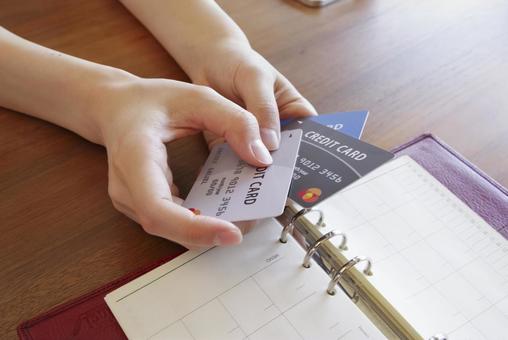 複数のカードを見ながら家計管理する女性 複数のカードを見ながら家計管理する女性 クレジットカード,支払い,家計管理の写真素材
