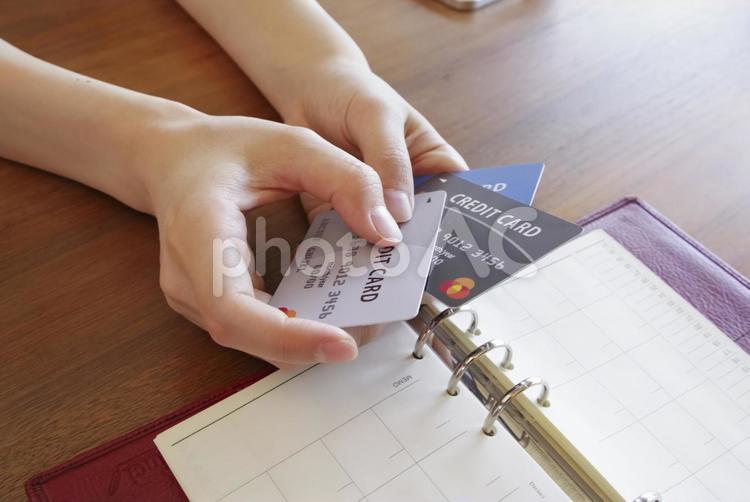 複数のカードを見ながら家計管理する女性 クレジットカード,支払い,家計管理の写真素材